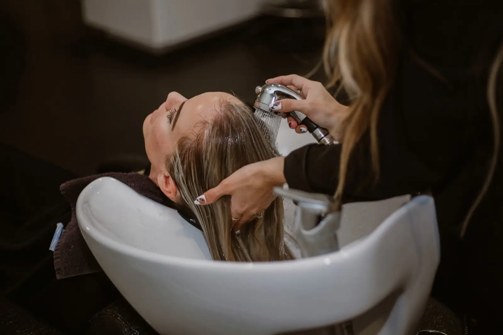 Coiffeuse wäscht einer Kundin die Haare: Website für Coiffeursalons und Kosmetikstudios in Thun