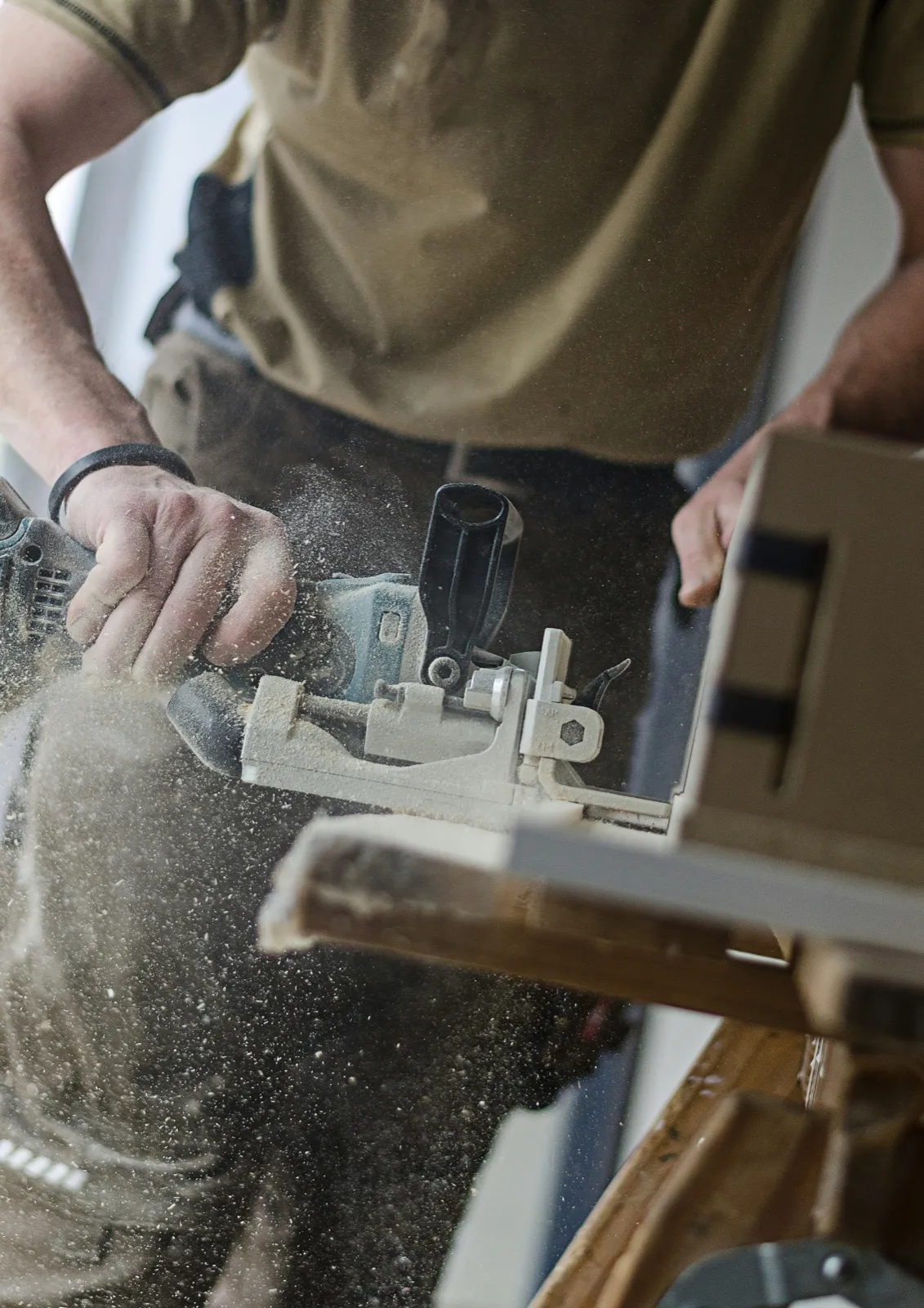 Schreiner fräst ein Holzbrett, Späne fliegen: Website für Handwerksbetriebe in Thun